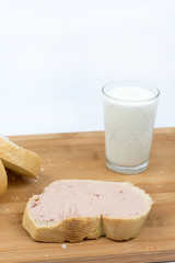 Pate on the bread, glass with yogurt on the wooden board
