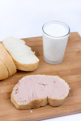 Pate on the bread, glass with yogurt on the wooden board