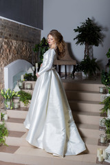 beautiful sweet girl elegant bride in an elegant wedding platestoit on the stairs