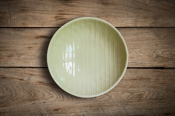 Blank green dish on a wood background.