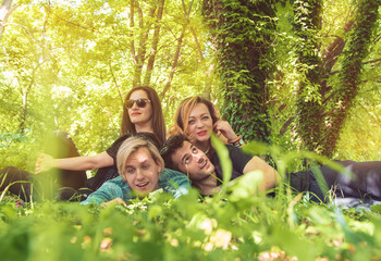 Fototapeta premium Group of young friends sitting on grass and relaxing