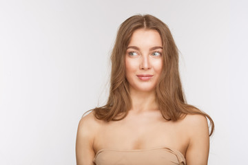 Obraz premium Portrait of beautiful model lady with perfect makeup over white background in studio. Pretty woman looking away and smiling for camera. Studio shot.
