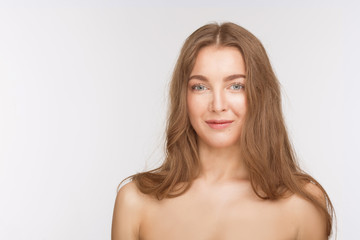 Portrait of happy beautiful shirtless lady posing for photographer over white background. Woman with brown hair looking at camera.