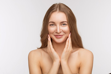 Portrait of happy smiling beautiful shirtless lady touching her face over white background. Pretty woman with red lips posing for fashion or vogue magazine.