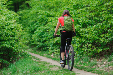 Fototapeta na wymiar Girl riding a bike in the woods