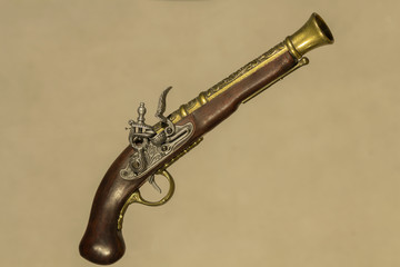 Vintage gun souvenir Brown with bronze on a beige background