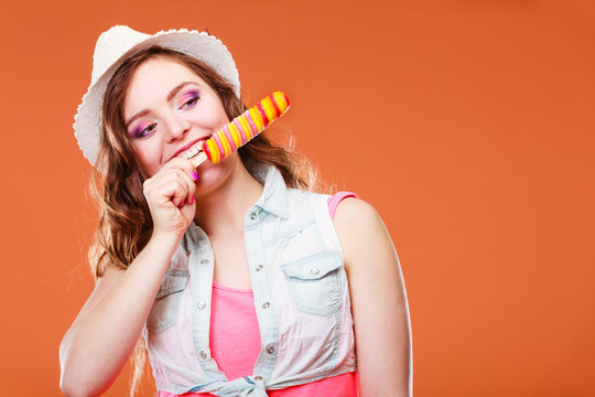 woman in summer hat eating ice pop cream