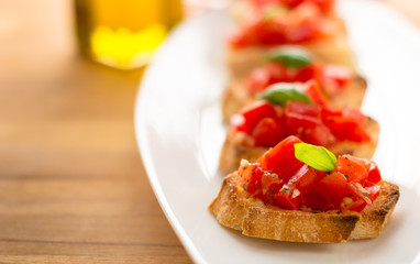 Bruschetta is an italian food made of chopped tomatoes, garlic, basil and fresh herbs on a toasted bread. These are traditionally served as snacks or antipasti (appetizers).