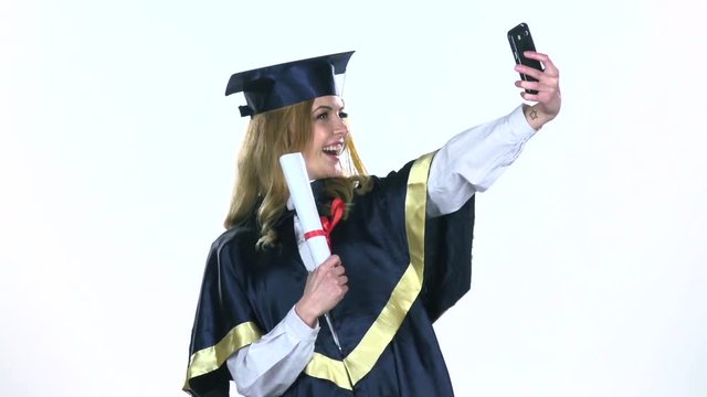 Female graduate makes selfie photo with diploma. White. Slow motion