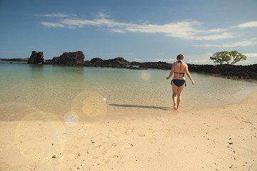Woman at tropical ocean beach on Big Island Hawaii
