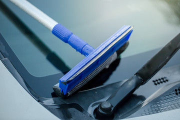 People cleaning car glass using cleaning brush