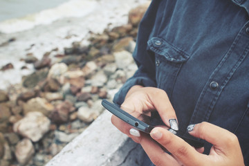 Woman using smart phone on the sea