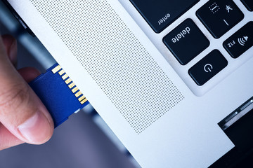 Plugging in SD Card into personal computer ready for photo file transfer