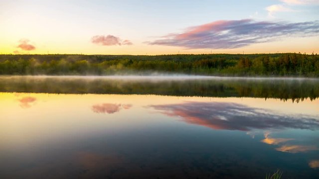Mist over the lake at sunset. Time-lapse