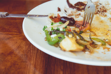 Left over food over dish on top of wooden table