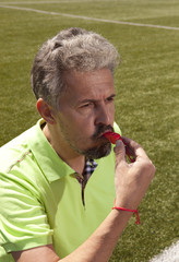 Angry football referee blowing a whistle