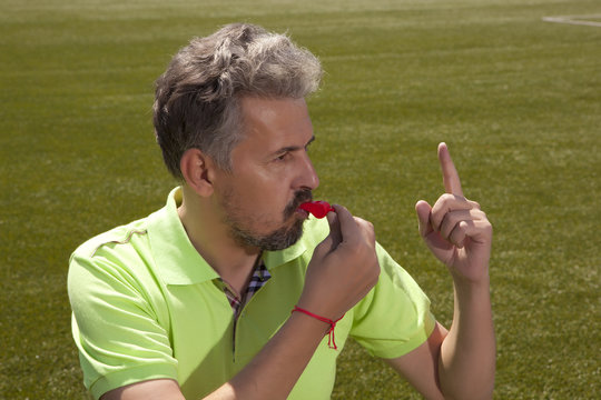 Angry football referee blowing a whistle