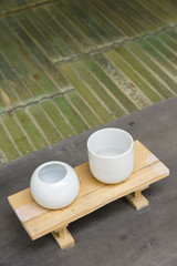 Japanese teacup over wooden table and bamboo floor. Asian background