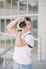 Photographer take a photo. Portrait of young man, tourist with camera