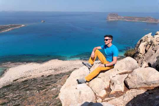 young man sitting on the rock in front of the sea