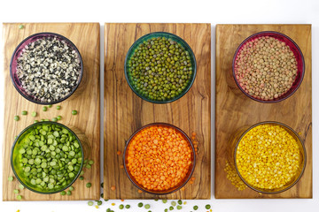 Multicolored clear glasses with various legumes ( green peas, re