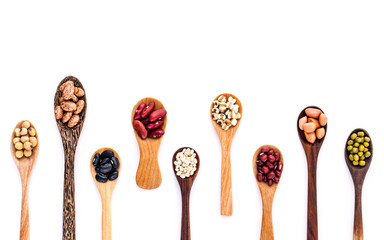 Assortment of beans and lentils in wooden spoon isolate on white