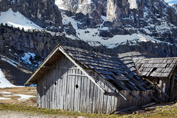 Alpine meadow with old wooden farmhouse.