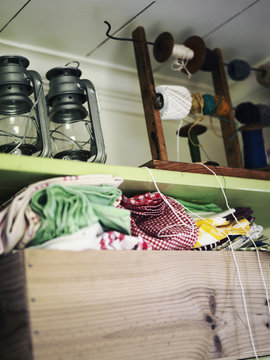 Paraffin lamps, textiles and spools on shelf