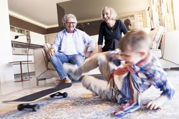 couple of happy grandparents are fun nephew with skateboard