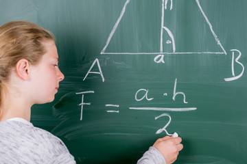 schüler schreibt rechenformel an die tafel