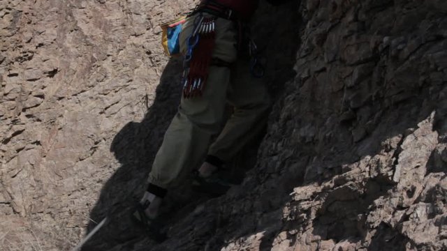  Climber begins climbing rocky terrain 