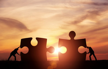 Teamwork concept. Two businessman connecting puzzle pieces