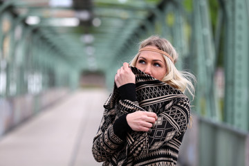Beautiful blonde woman hiding her face behind her vest
