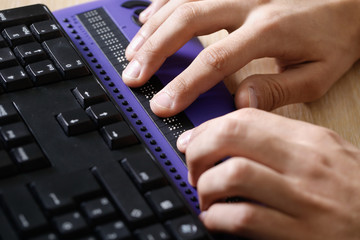 Blind person using computer with braille computer display - obrazy, fototapety, plakaty