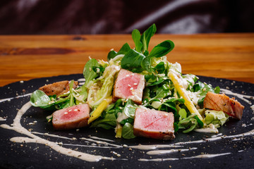 Seared tuna coated sesame seeds with green salad on plate