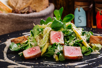 Seared tuna coated sesame seeds with green salad on plate