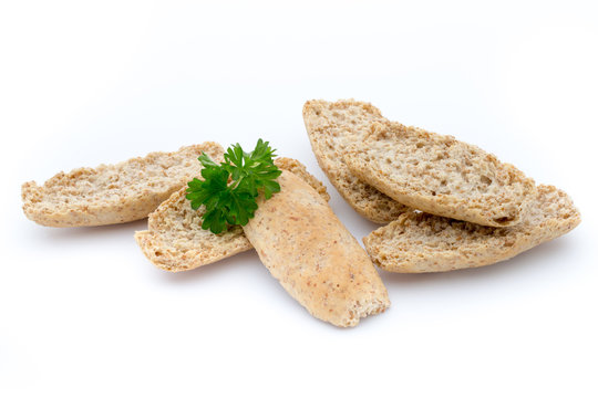 Dry flat bread crisps with herbs on a white background.
