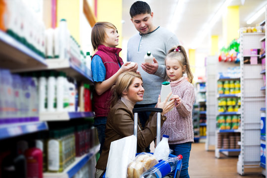 Family of four selecting shower gel in shop