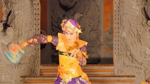woman dancing balinese traditional barong dance in costume on stage performance indoor model release signed