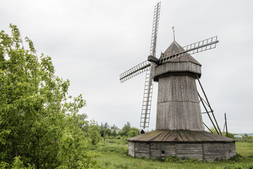 Old wind mill at the park with gray sky clouds