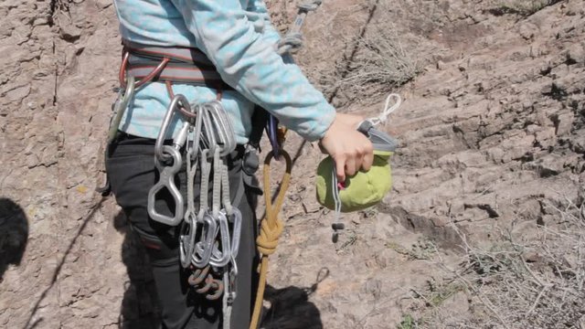 Climber uses a bag of talcum powder before climbing on the rock
