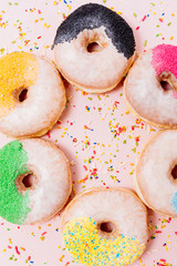 Stack of assorted donuts on a pink background