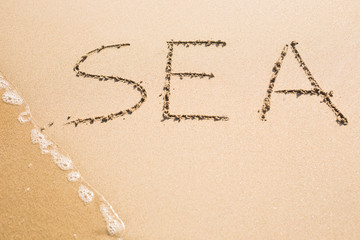 word SEA on the sand