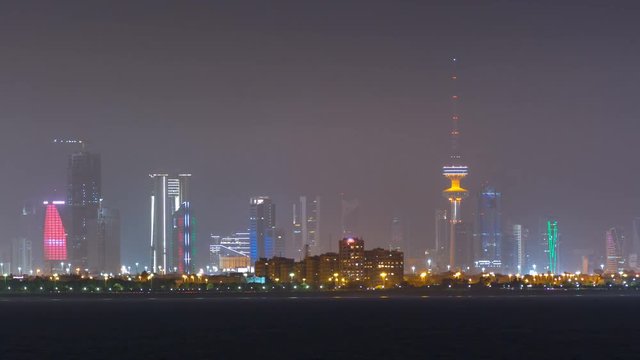 Skyline with Skyscrapers night timelapse in Kuwait City downtown illuminated at dusk. Kuwait City, Middle East