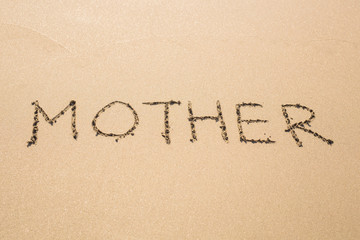 word mom in the sand on a beach