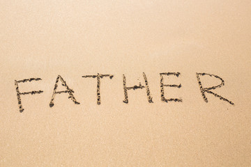 Fototapeta na wymiar Father hand written in the sandy beach