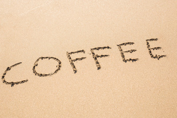 Fototapeta na wymiar coffee drawn on sand beach