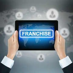 FRANCHISE sign on tablet pc screen held by businessman hands