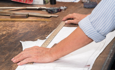 Tailor or clothing designer marking out a pattern for a handmade garment 
