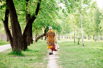 Fototapeta premium the grandmother comes back from shop with purchases